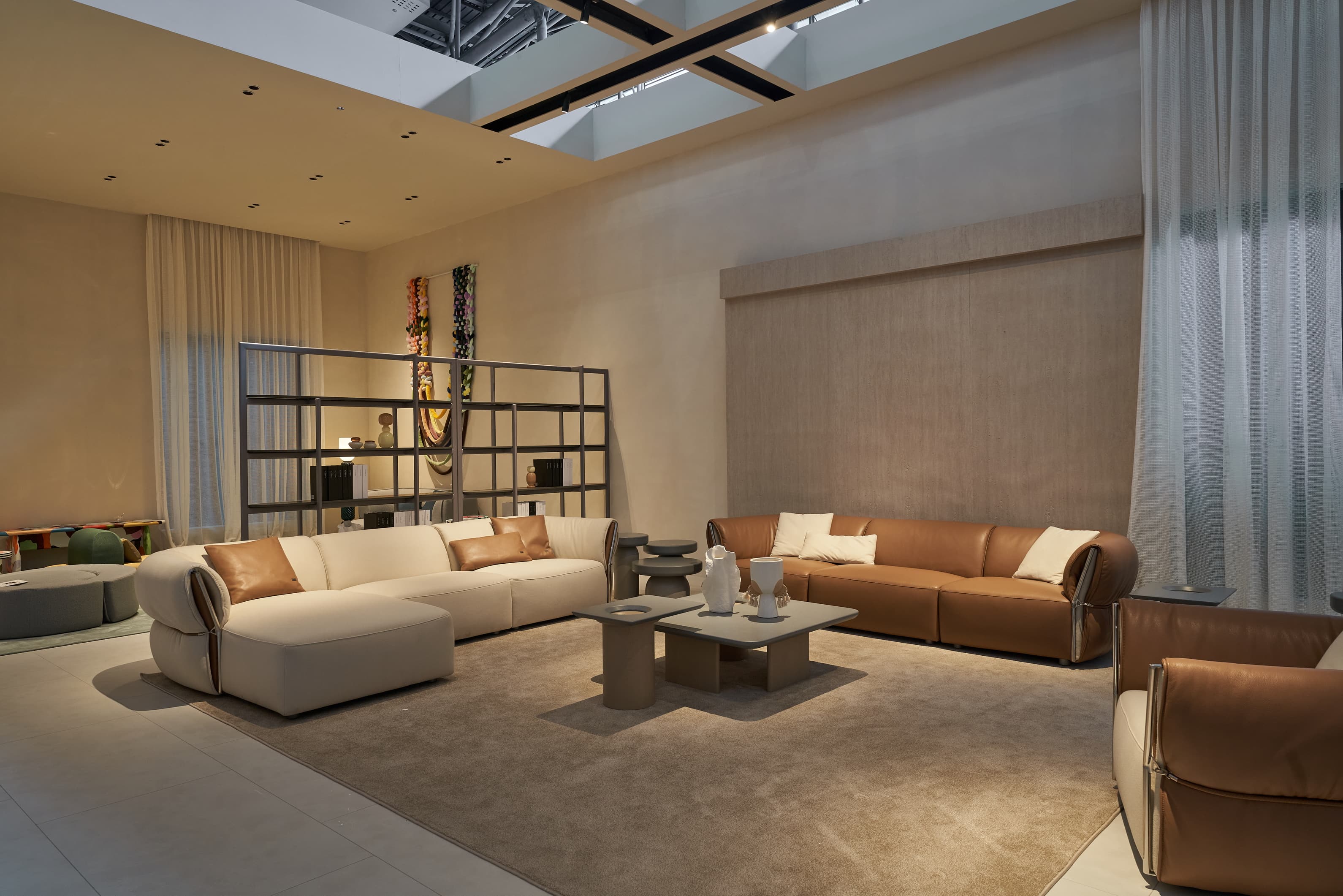 Modern living room with beige and brown sofas, a coffee table, and decorative items.
